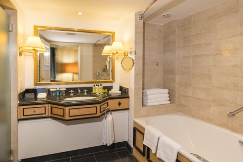 Badezimmer einer Suite mit separater Badewanne und Dusche
