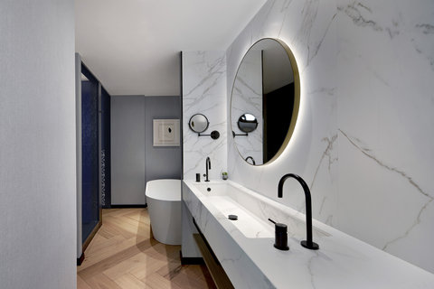 Elegante mármol y amplia bañera en los baños de nuestras suites